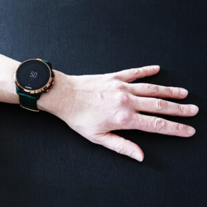 En hand med en pulsklocka som visar 50 mot svart bakgrund. 
